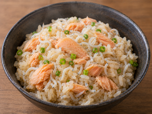 炊飯器の蓋を開けた瞬間、極厚のサケ（しゃけ）とたっぷりの釜揚げしらす（シラス）が綺麗に並んだ炊き込みご飯